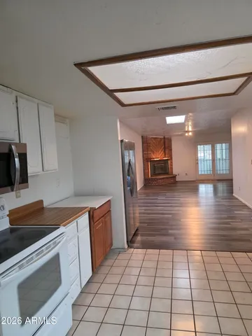 a kitchen with granite countertop a stove a sink and a refrigerator