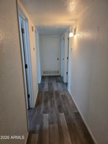 a view of a hallway with wooden floor