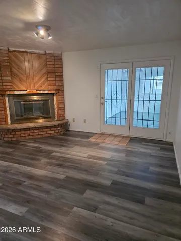 an empty room with wooden floor and a fireplace