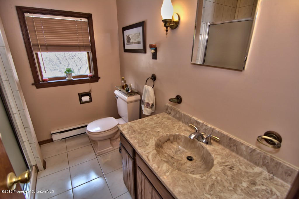 28 Elias Road Moscow, PA 18444 - Photo 18 of 69 a bathroom with a granite countertop sink mirror vanity and toilet