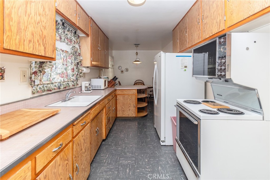 630 Acoma Street Needles, CA 92363 - Photo 12 of 60 a kitchen with a sink stove and refrigerator