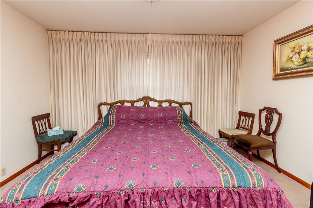 630 Acoma Street Needles, CA 92363 - Photo 16 of 60 a bed sitting in a bedroom next to a window with chair and couch