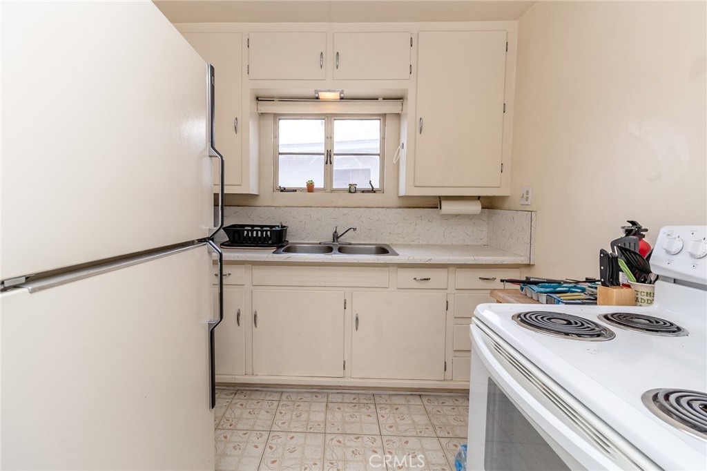 630 Acoma Street Needles, CA 92363 - Photo 39 of 60 a kitchen with a sink a stove and white cabinets