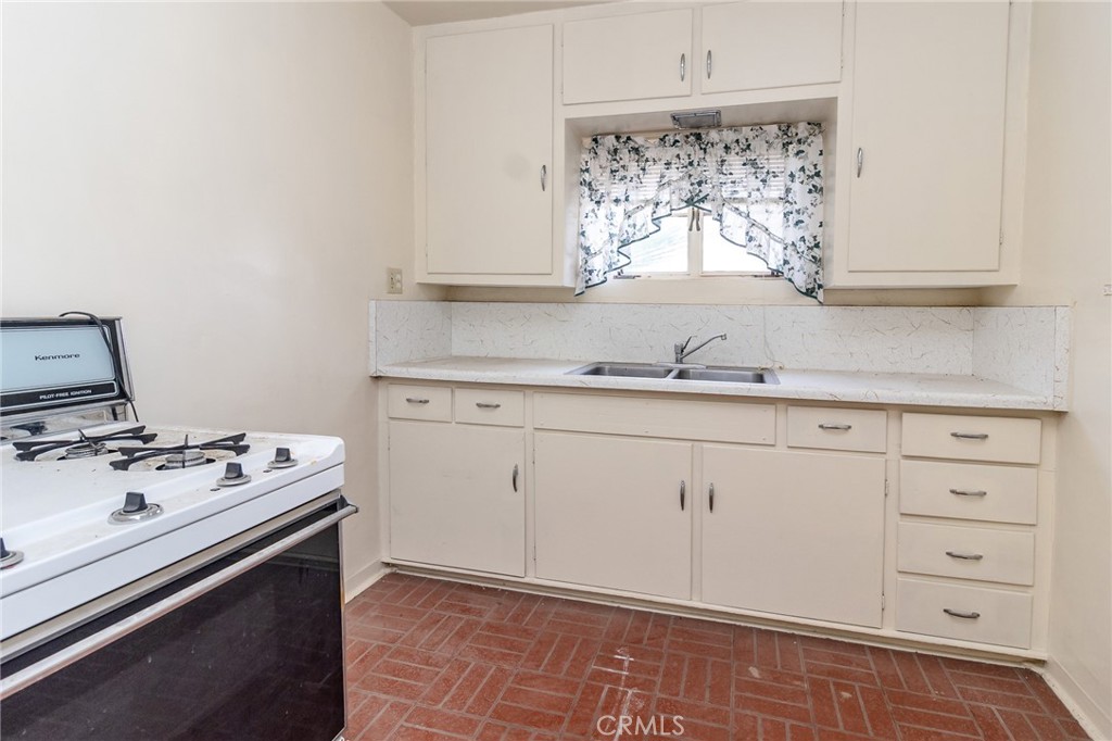 630 Acoma Street Needles, CA 92363 - Photo 50 of 60 a kitchen with a stove window and cabinets