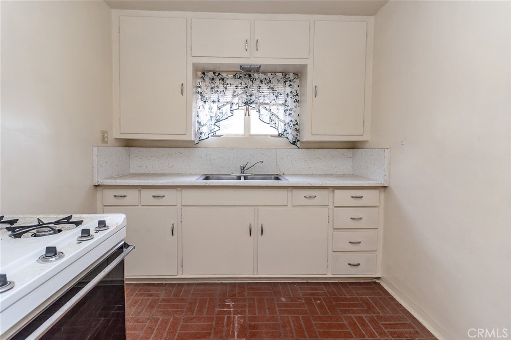 630 Acoma Street Needles, CA 92363 - Photo 51 of 60 a kitchen with granite countertop white cabinets and white appliances