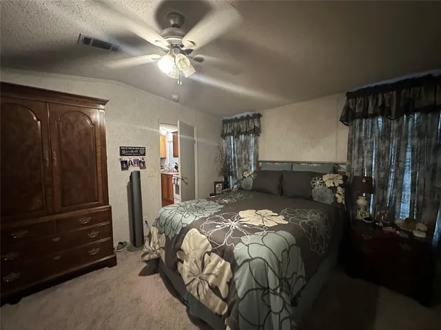 a bed room with a bed and a ceiling fan