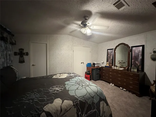 a bedroom with a bed mirror and window