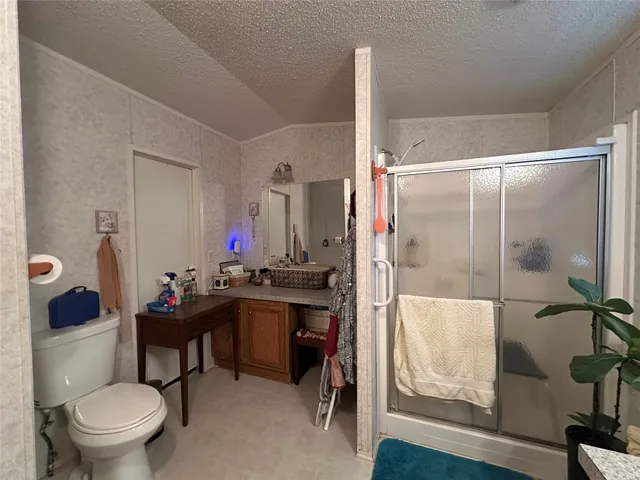 a bathroom with a granite countertop bathtub shower sink mirror and toilet
