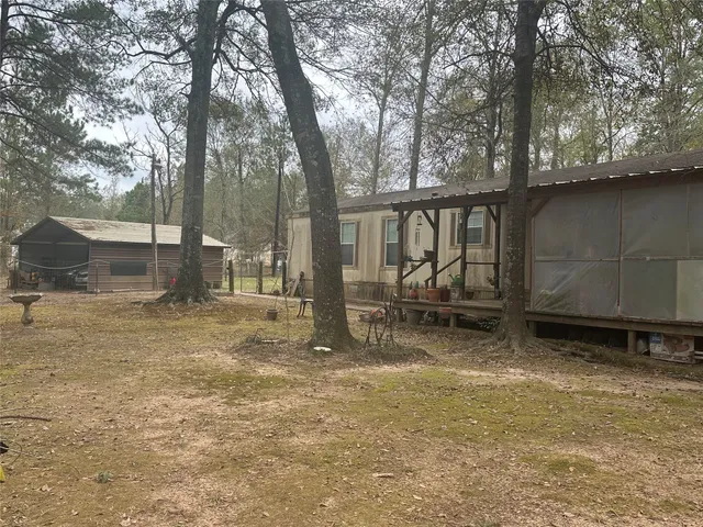a view of a backyard with wooden fence and a large tree