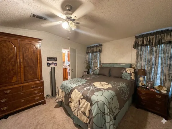 a bedroom with a bed dresser and window
