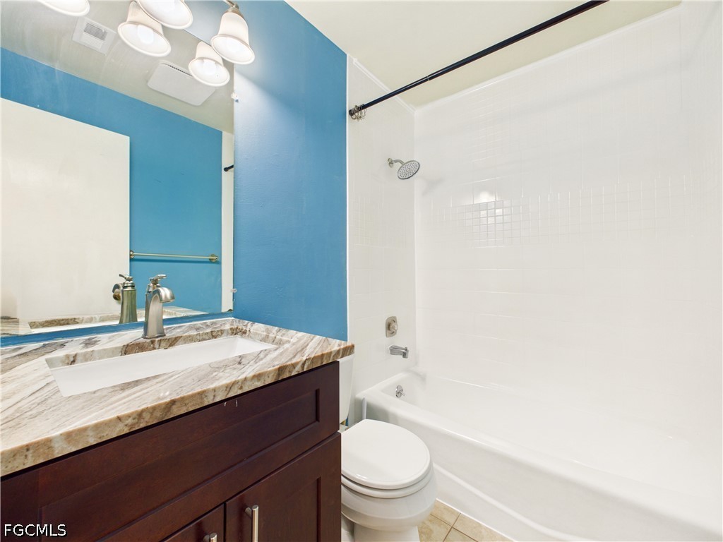18541 Iris Road Fort Myers, FL 33967 - Photo 11 of 18 a bathroom with a granite countertop sink toilet mirror vanity and bathtub
