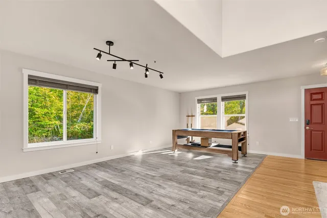 a view of a livingroom with wooden floor and furniture