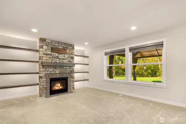 an empty room with windows and fireplace