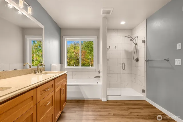 a bathroom with a tub sink shower and a mirror