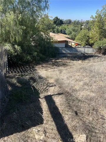 a view of a yard with wooden fence