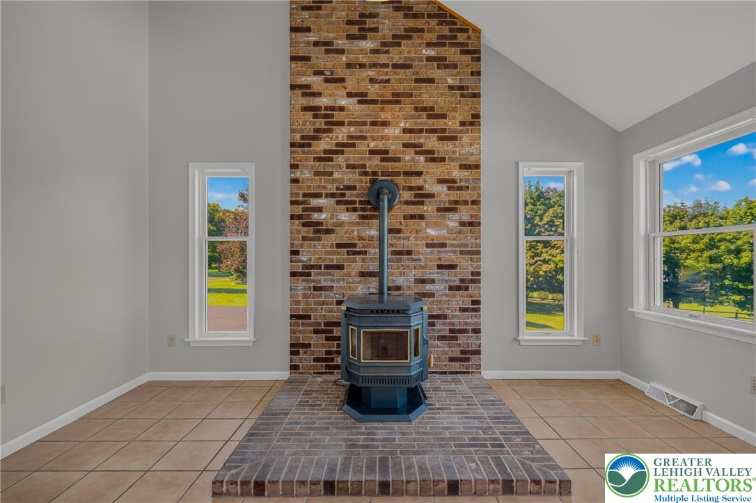 630 Clearfield Road Nazareth, PA 18064 - Photo 39 of 100 Vaulted ceilings and a floor-to-ceiling brick fireplace surround anchor this sun-filled room.