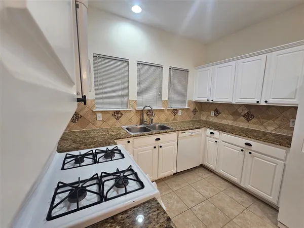 a kitchen with sink a stove and cabinets