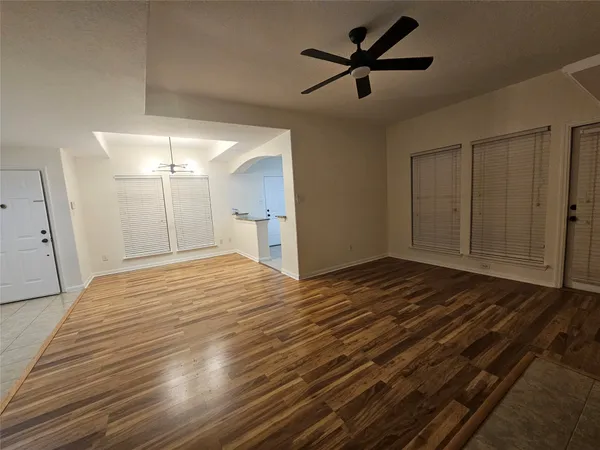 a view of a room with wooden floor and a ceiling fan