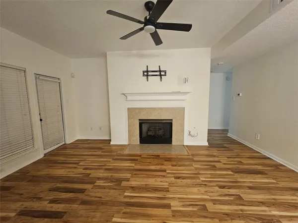 a view of a livingroom with a fireplace a ceiling fan and a rug