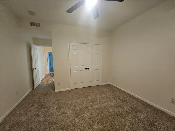 an empty room with an entryway and closet