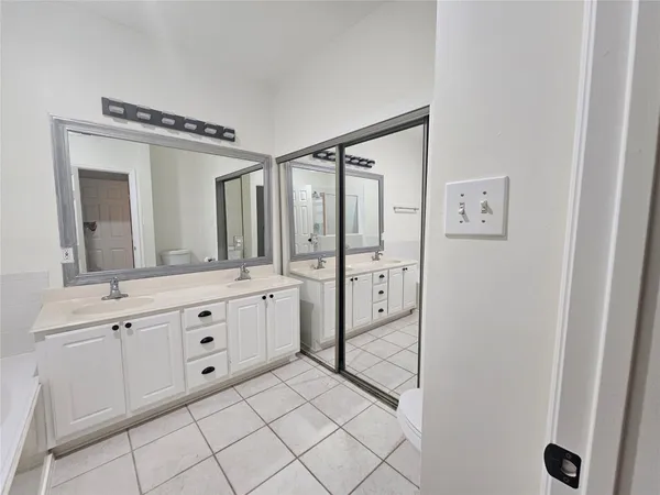 a spacious bathroom with a double vanity sink mirror and shower