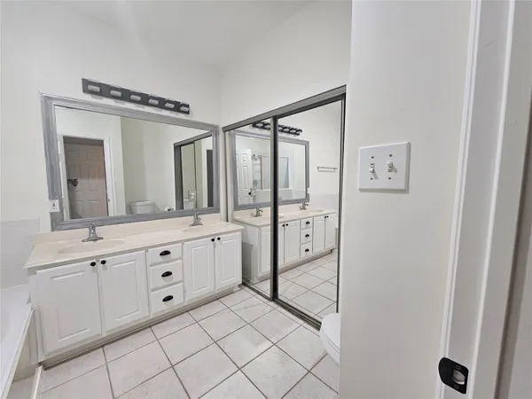a spacious bathroom with a double vanity sink mirror and shower