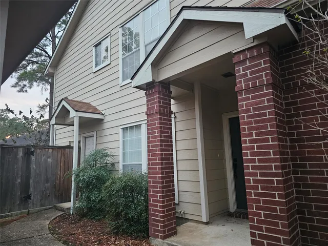 a view of brick house with a window and potted plants