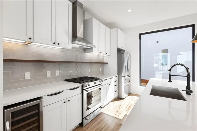 a kitchen with stainless steel appliances granite countertop a stove a sink and a refrigerator