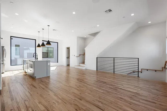 a view of a big room with wooden floor and windows