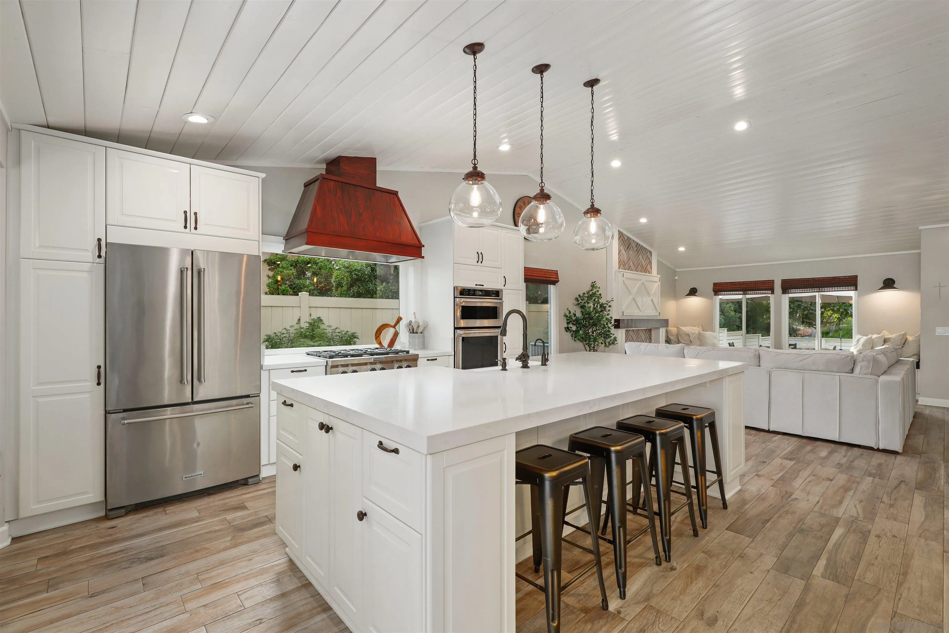 14717 Fieldview Way Poway, CA 92064 - Photo 15 of 35 a kitchen with stainless steel appliances kitchen island granite countertop a refrigerator a stove a microwave oven a dining table and chairs with wooden floor