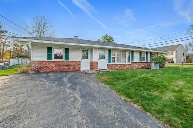 a front view of a house with a yard and potted plants