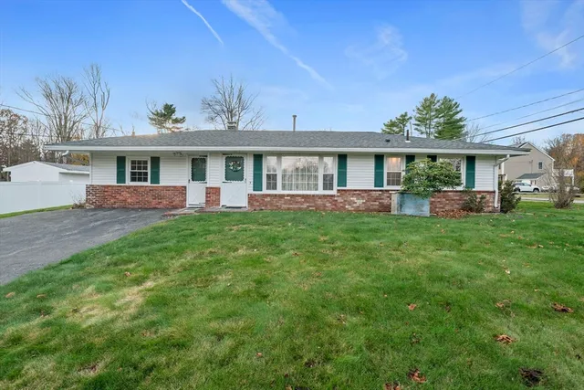 a front view of a house with a yard and potted plants
