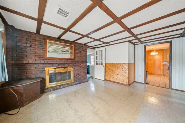 a view of an empty room with a fireplace and a window