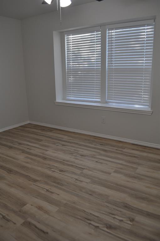 2360 Murphy Court Waxahachie, TX 75165 - Photo 12 of 22 a view of an empty room with wooden floor and a window