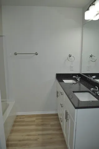 a bathroom with a granite countertop toilet and a sink