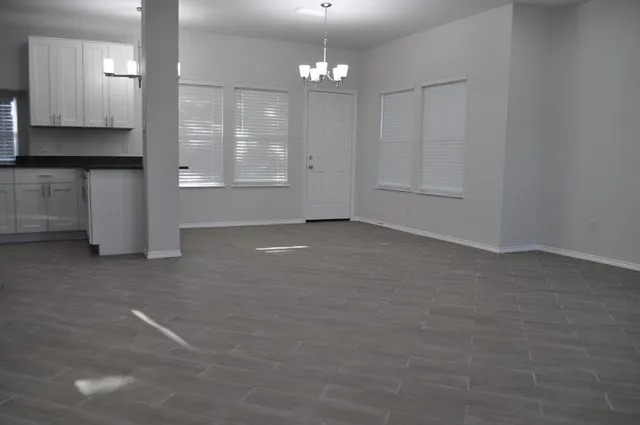 an empty room with windows and cabinet
