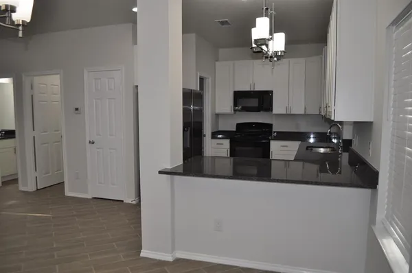 a view of a kitchen with refrigerator and microwave