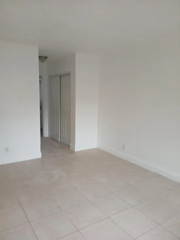 a view of an empty room and chandelier fan