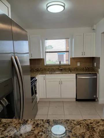 a kitchen with a sink a stove a refrigerator and cabinets