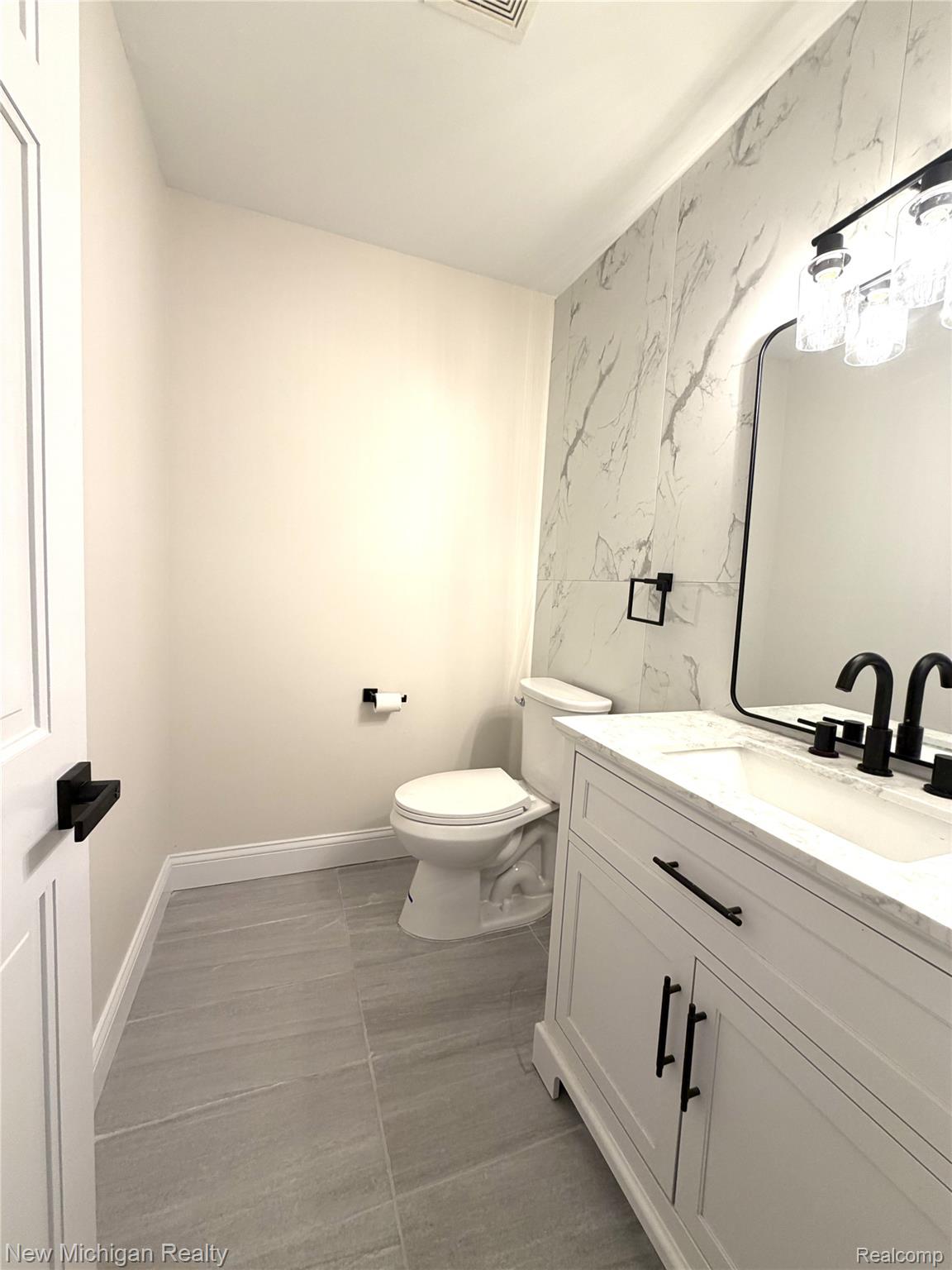 650 Deerfield Court Rochester, MI 48309 - Photo 17 of 37 Fully updated and contemporary powder room featuring modern fixtures, and a marble-patterned accent wall