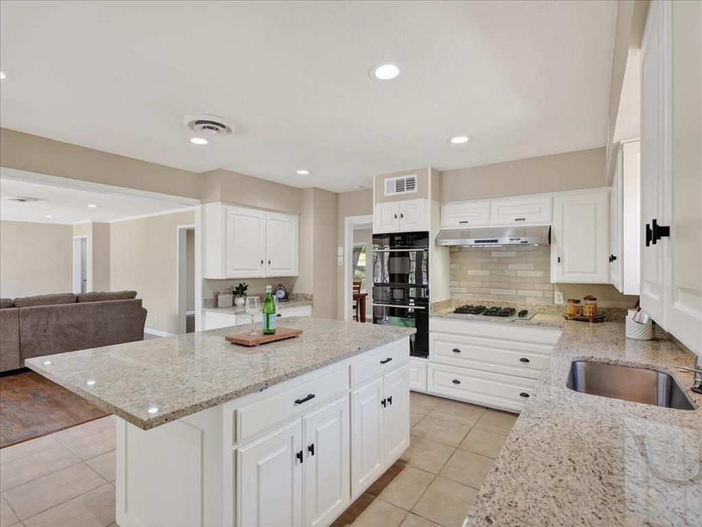 3863 Clayton Road East Fort Worth, TX 76116 - Photo 38 of 39 a kitchen with granite countertop a sink a stove cabinets and counter space