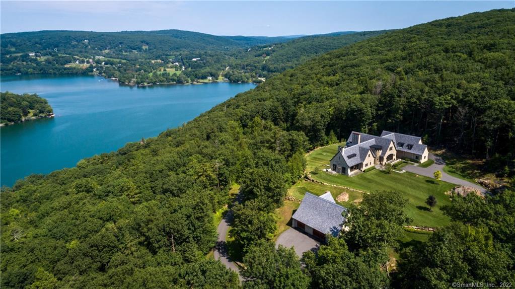 an aerial view of a house with a yard and lake view