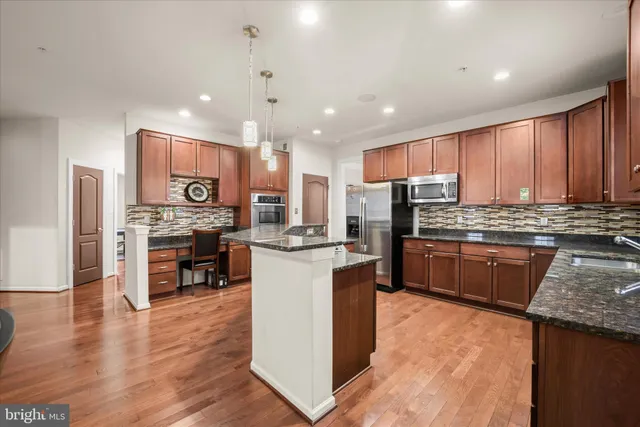 a kitchen with stainless steel appliances granite countertop a stove and a refrigerator