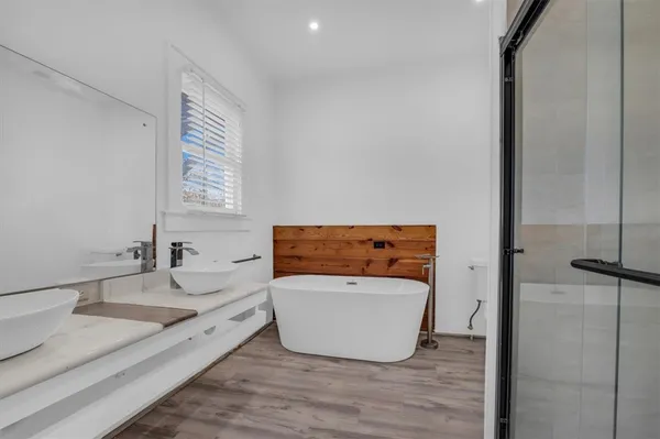 a bathroom with a tub sink and mirror