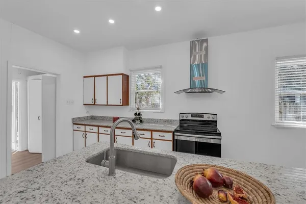 a kitchen with stainless steel appliances a stove a sink and a refrigerator