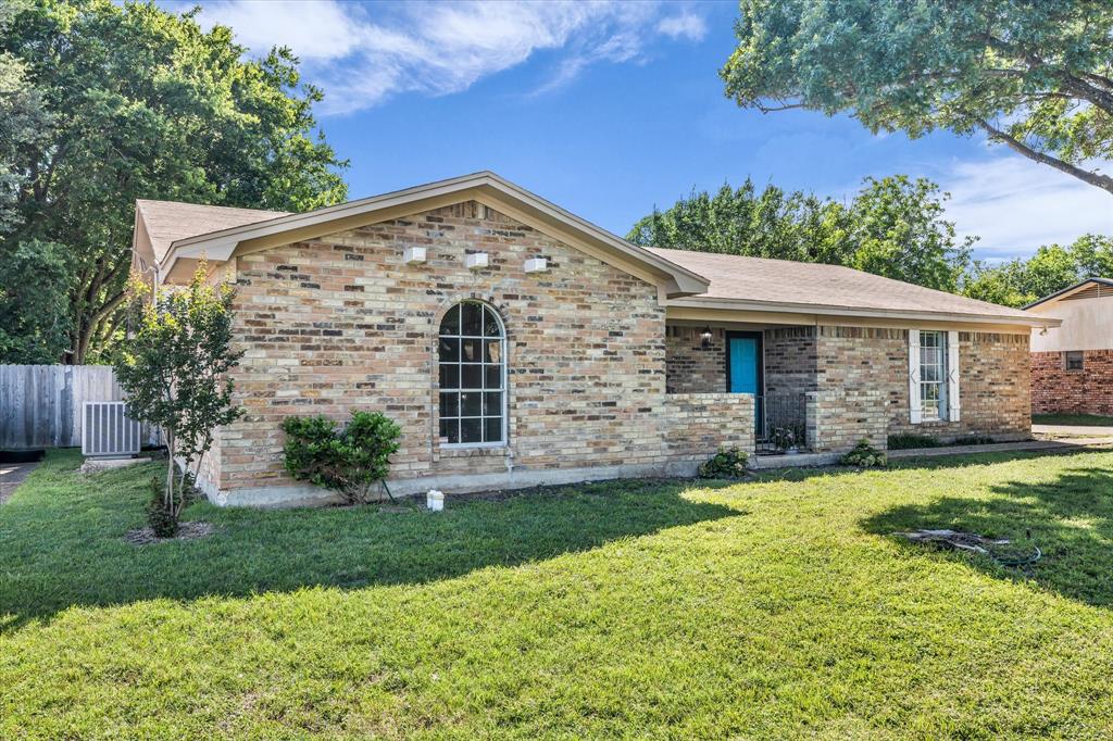 141 Travis Lane Hewitt, TX 76643 - Photo 2 of 31 Brick exterior architecture with a prominent arched window and a bright blue entry door