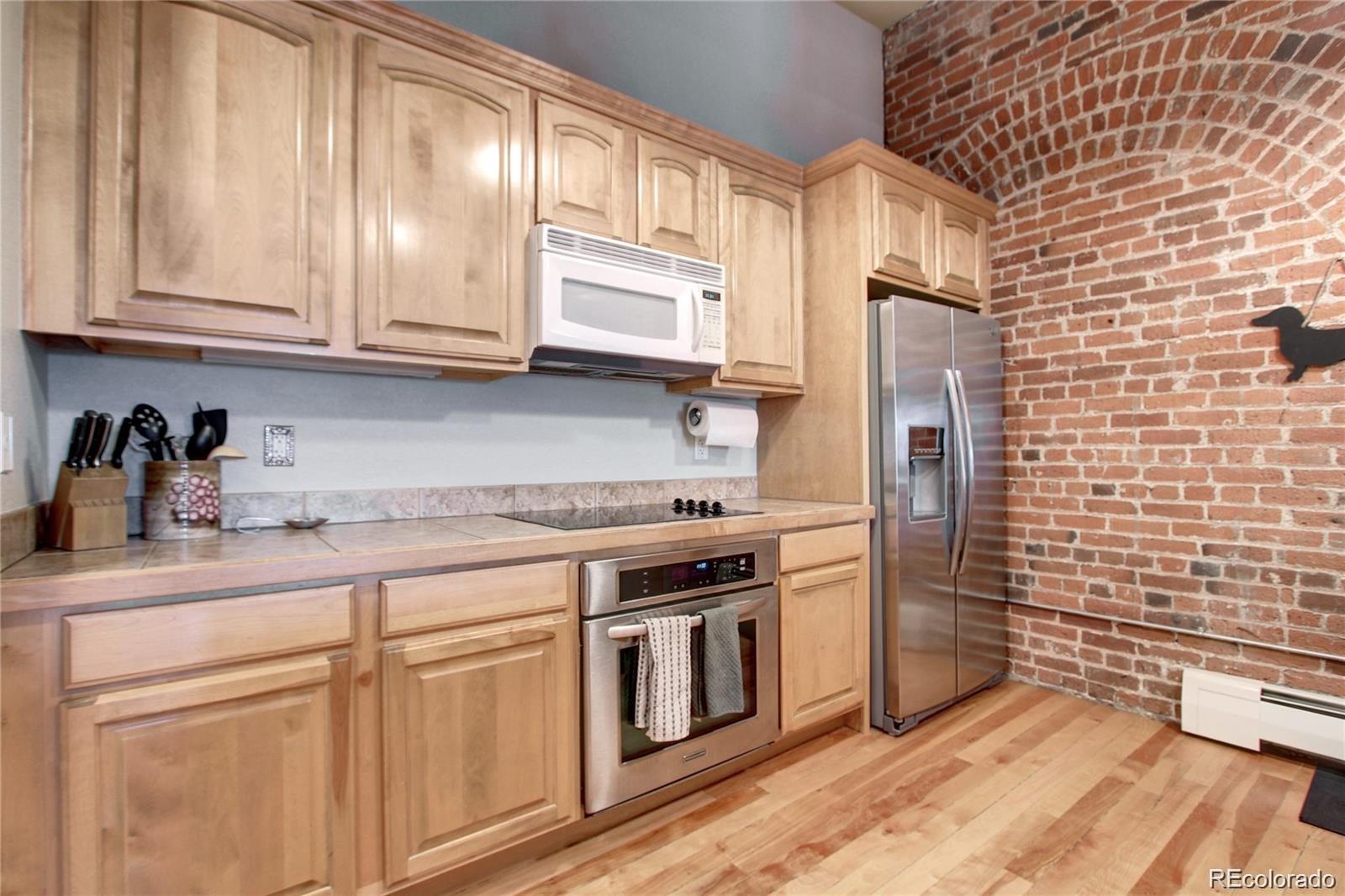2560 Blake Street, Unit 203 Denver, CO 80205 - Photo 12 of 23 a kitchen with stainless steel appliances granite countertop a stove a sink and dishwasher refrigerator a cabinets