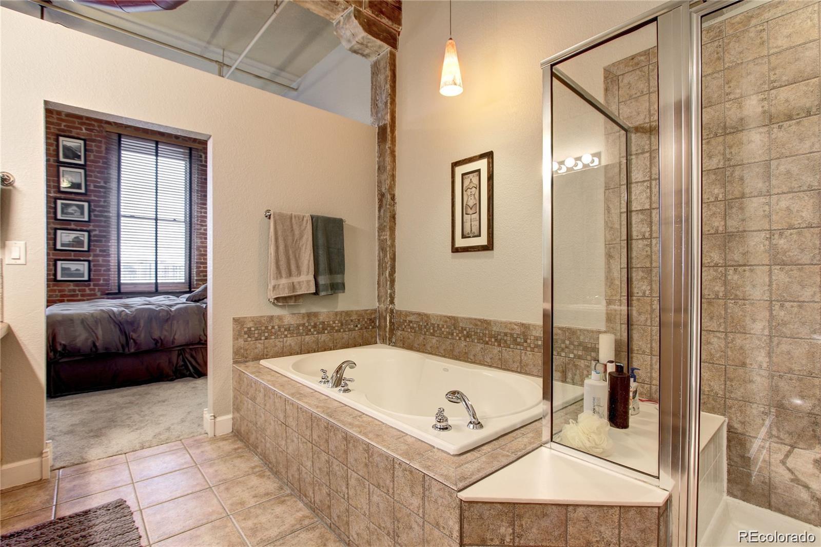 2560 Blake Street, Unit 203 Denver, CO 80205 - Photo 21 of 23 a bathroom with a tub a window and a shower