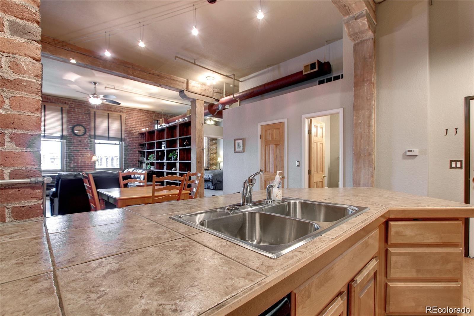 2560 Blake Street, Unit 203 Denver, CO 80205 - Photo 10 of 23 a kitchen with stainless steel appliances granite countertop a sink a oven and a view of living room