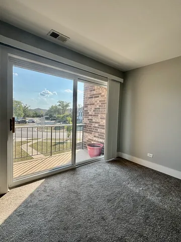 a view of an empty room with wooden floor and door